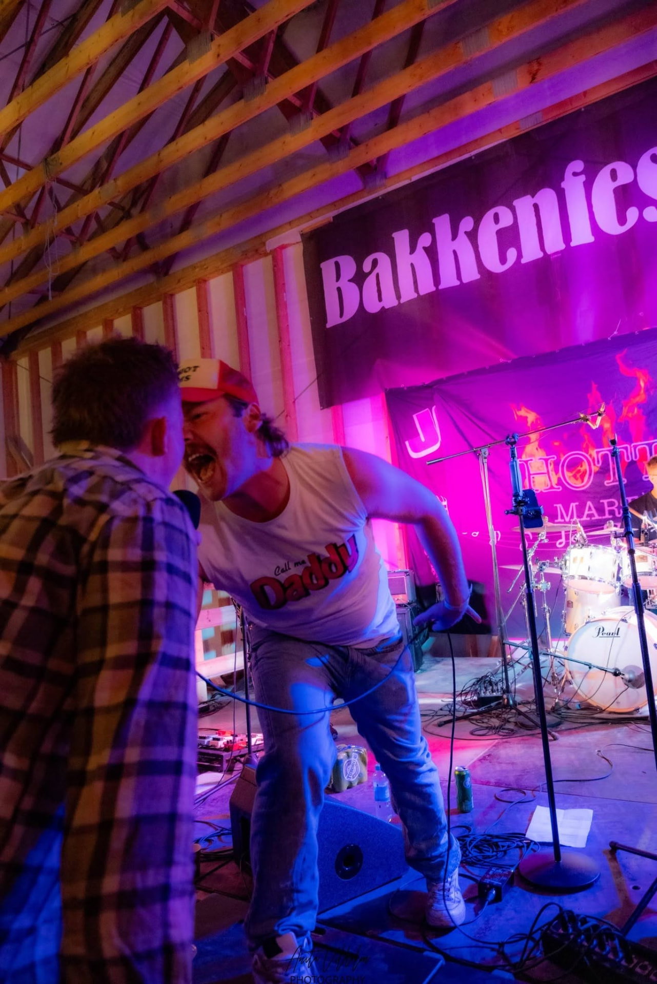 Vokalist synger til publikum foran Bakkenfestivalen-banneret