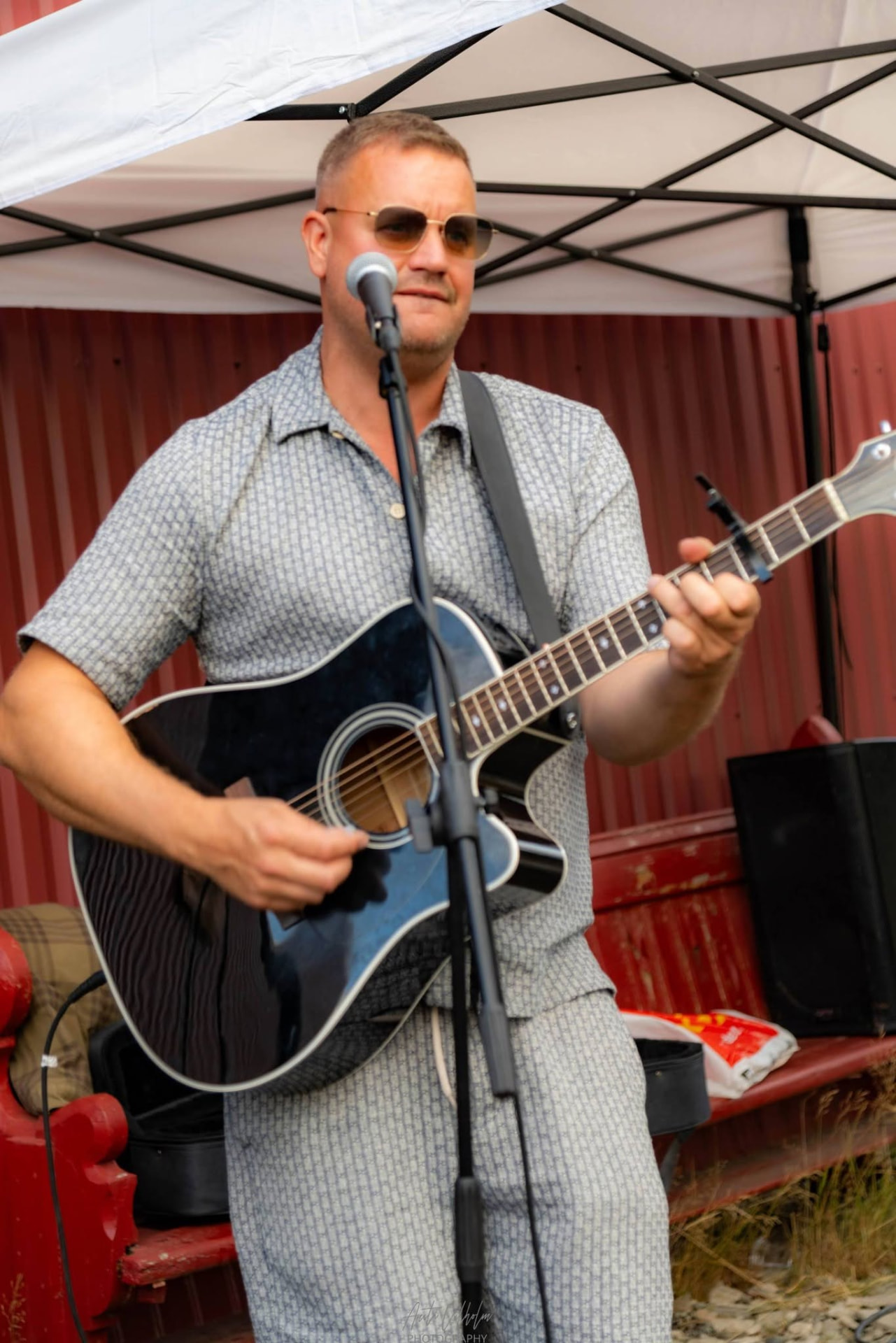 Artist med gitar under teltet ute