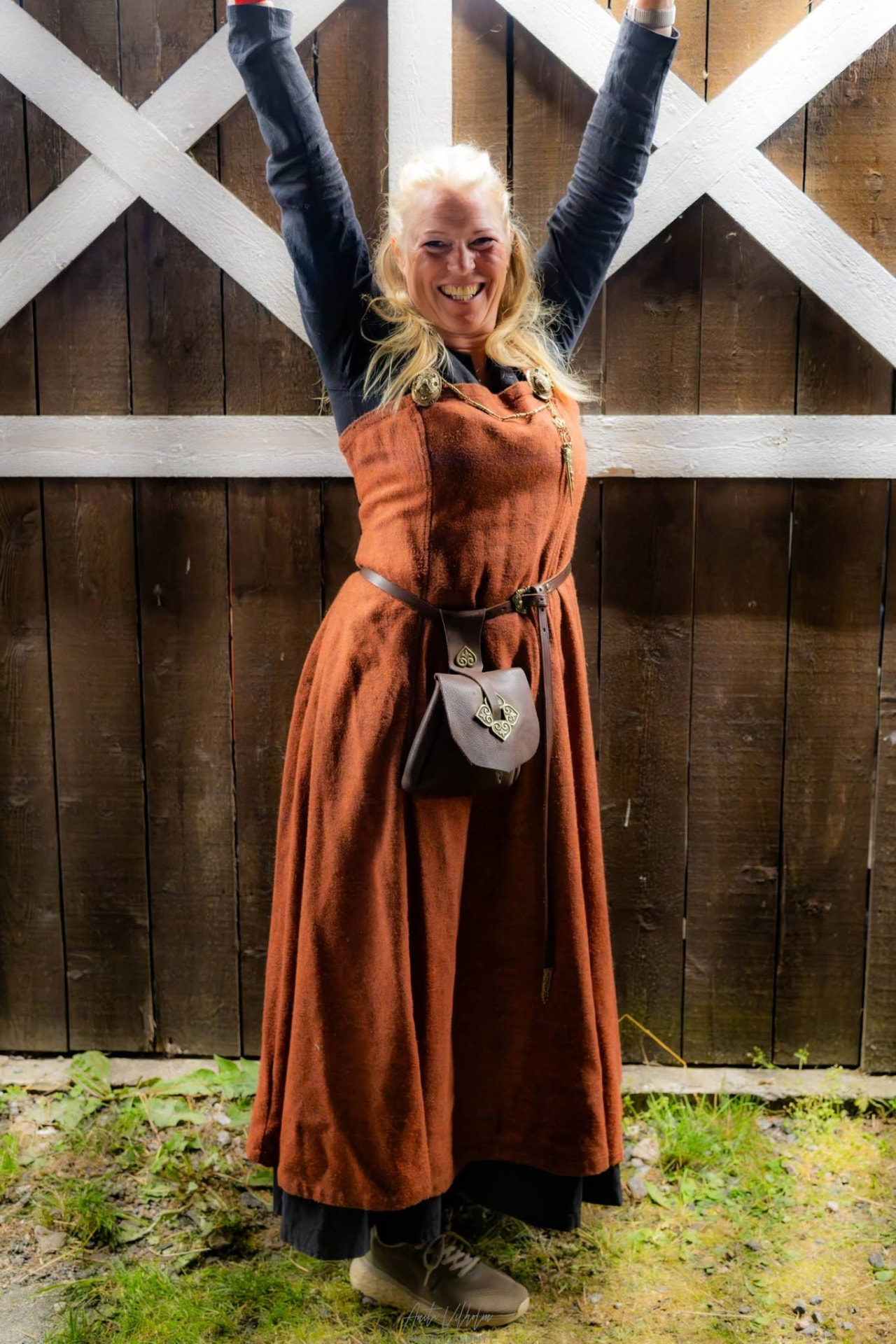 Festivalgjest i vikingdrakt foran låvedøra